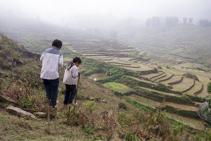 Little boys on bamboo stilts