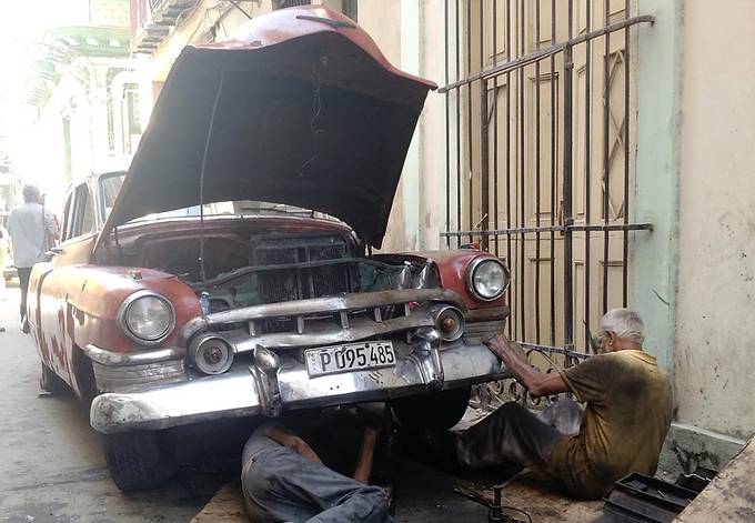 Mechanics fixing a classic car